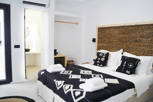 una camera da letto con un grande letto con cuscini bianchi e neri di King's Suites a Kamari