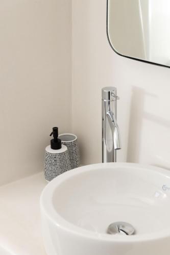 a white sink in a bathroom with a mirror at Archon Seaside Retreat in Plaka