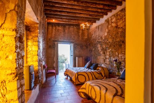a bedroom with two beds in a stone wall at Villas de Santa Ana in Manuel F. Martínez