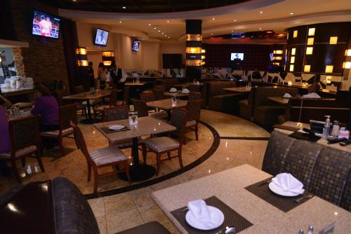 a restaurant with tables and chairs and people sitting in it at Hotel Ticuán in Tijuana