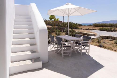 a table and chairs and an umbrella on a patio at Archon Seaside Retreat in Plaka