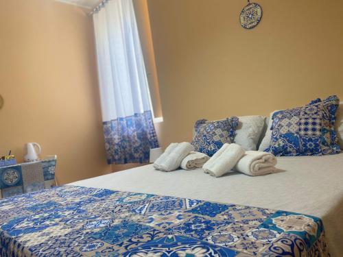 a bedroom with a bed with towels on it at Le Maioliche BLU Sferracavallo in Sferracavallo