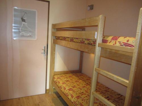1 Schlafzimmer mit 2 Etagenbetten und einer Tür in der Unterkunft Studio Brides-les-Bains, 1 pièce, 4 personnes - FR-1-512-242 in Brides-les-Bains