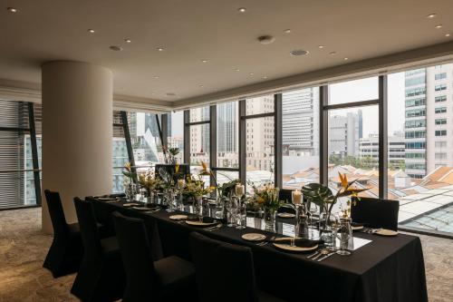 a long table in a room with a large window at The Clan Hotel Singapore by Far East Hospitality in Singapore