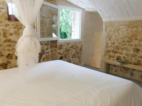 - une chambre avec un lit blanc et une fenêtre dans l'établissement L'Appartement de Séraphin, à Navacelles