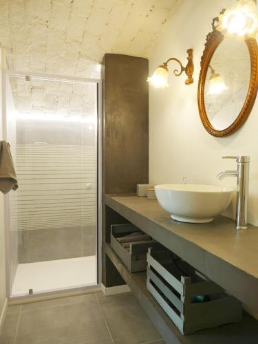 une salle de bain avec un lavabo et une douche en verre dans l'établissement L'Appartement de Séraphin, à Navacelles