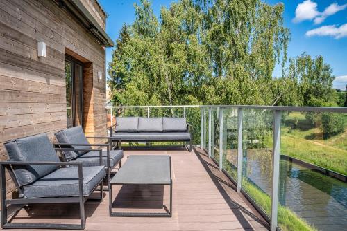 a deck with chairs and a table and water at Nautica Resort in Giżycko