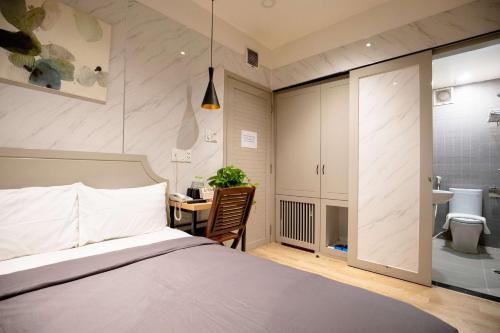 胡志明市的住宿－Lá Hotel Q10，一间带一张床和一张书桌的卧室以及一间浴室。