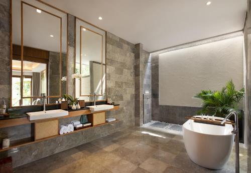 a bathroom with two sinks and a bath tub at Adiwana Suweta in Ubud