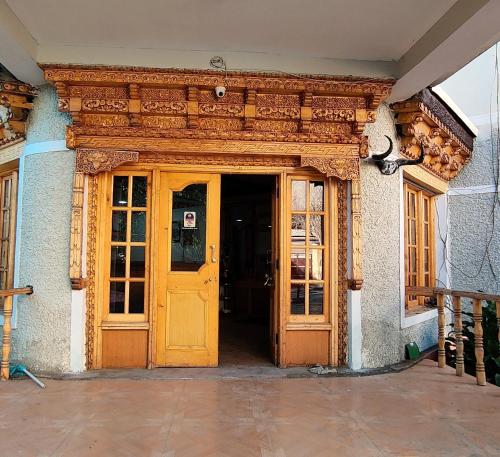 una entrada a un edificio con una puerta amarilla en Hotel Royal Plaza, en Leh