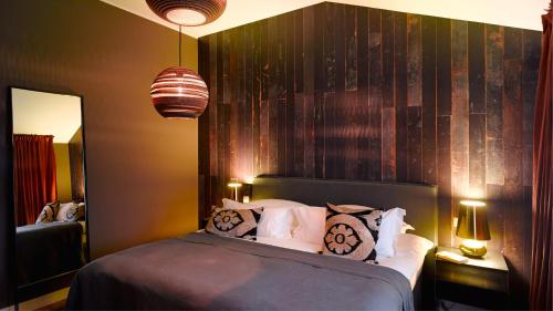 a bedroom with a bed and two lamps and a mirror at Gorki Apartments in Berlin