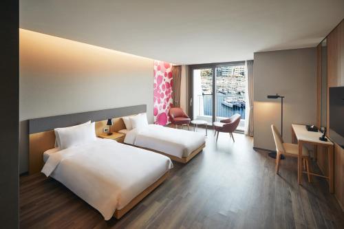 a hotel room with two beds and a desk at Yeosu Belle Mer in Yeosu