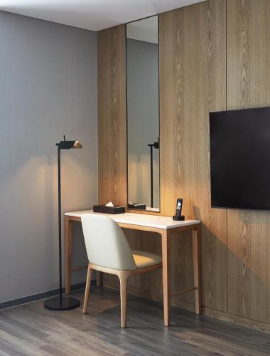 a desk with a chair and a television on a wall at Yeosu Belle Mer in Yeosu