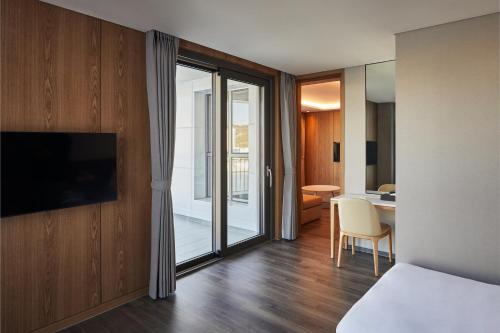 a hotel room with a bed and a sliding glass door at Yeosu Belle Mer in Yeosu