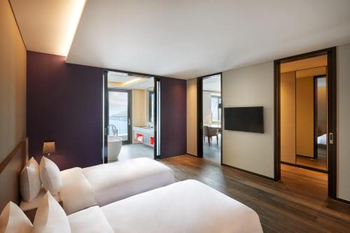 a bedroom with a white bed and a bathroom at Yeosu Belle Mer in Yeosu
