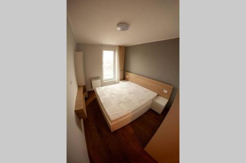 a small bedroom with a bed and a window at Diagonala 2 in Novi Sad