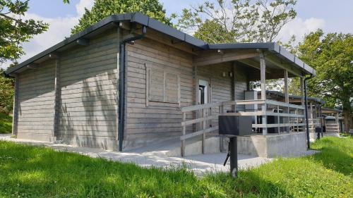 a small wooden building with a porch at Camping & Bungalows Leagi in Mendexa
