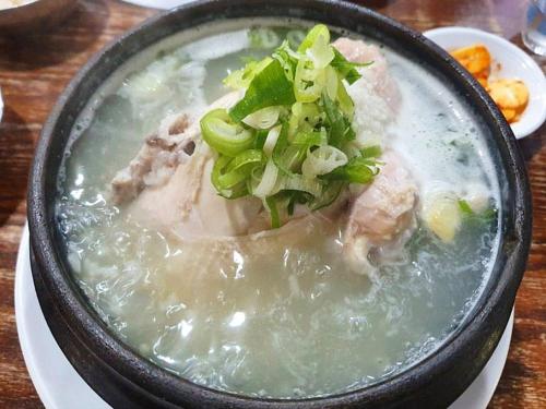 a bowl of soup with meat and vegetables on a table at Oyado Fubuki in Nozawa Onsen