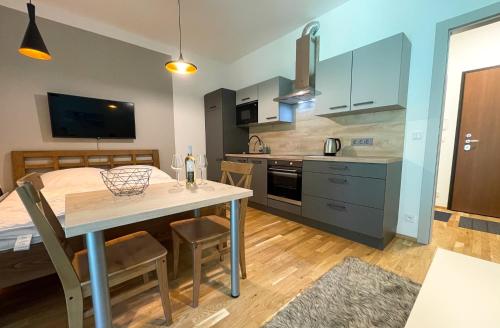 eine Küche und ein Wohnzimmer mit einem Tisch und einem Bett in der Unterkunft Apartmán Dolce Vita Harrachov 1.8 in Harrachov