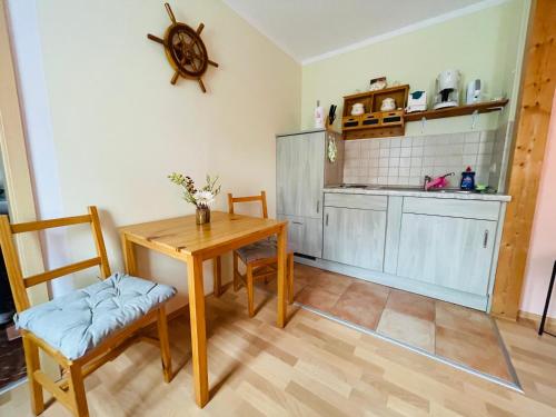 eine Küche mit einem Holztisch und Stühlen im Zimmer in der Unterkunft Kleine FeWo in Heringsdorf auf der Insel Usedom in Heringsdorf