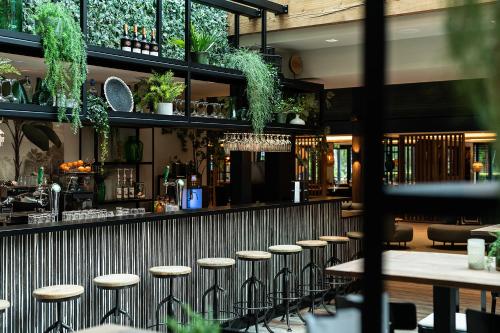 a bar with stools in a restaurant at Hotel de Werelt in Lunteren