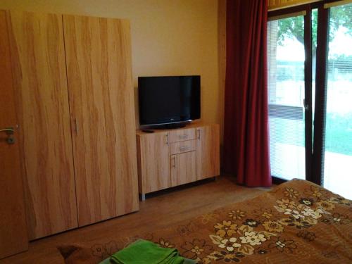 a room with a television on a cabinet with a window at Ranč Orlice in Třebechovice pod Orebem