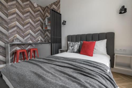 a bedroom with a large bed with red pillows at HARBOR APARTMENTS - Mariacka in Katowice