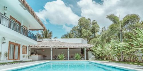 a swimming pool in front of a house at Ultra Mint Dive Resort in Panglao Island