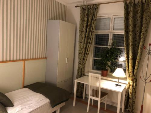 a small bedroom with a desk and a bed and a window at Hotelli Verstas in Nakkila