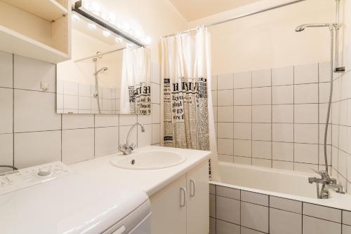 une salle de bain blanche avec un lavabo et une baignoire dans l'établissement La Digue, à Pléneuf-Val-André