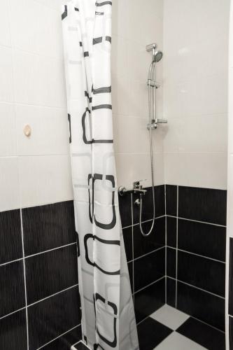a shower with a black and white shower curtain in a bathroom at CITY APARTMENT BB in Bajina Bašta
