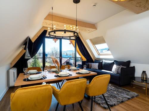 a dining room and living room with a table and chairs at Aparthotel Góralski Spa 2 in Białka Tatrzanska