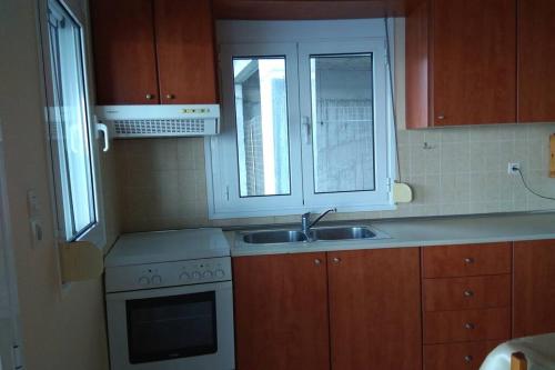 a kitchen with a sink and a stove at Tris Ekklisies Seaside Beach Apartment in Paránimfoi