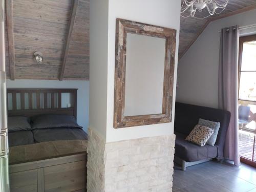 a bedroom with a bed and a mirror on a wall at Apartament z tarasem in Stegna
