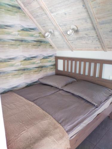 łóżko w pokoju ze ścianą w obiekcie Apartament z tarasem w Stegnie