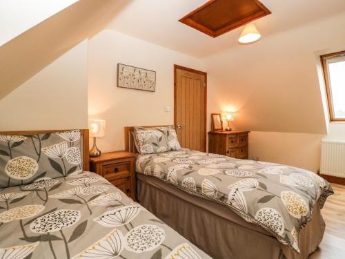 a bedroom with two beds and a window at Muskoka Lodge in Midsomer Norton