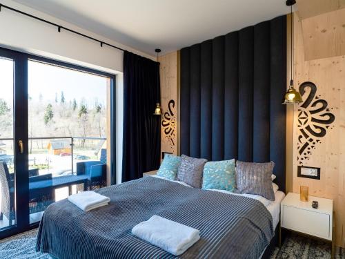 a bedroom with a large bed and a large window at Aparthotel Góralski Spa 2 in Białka Tatrzanska