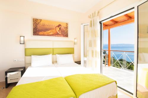 um quarto com uma cama grande e uma varanda em Brentanos Apartments - A - View of Paradise em Gastouri