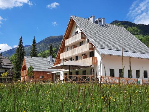 a large white building with a roof at Triangel Boutique Hotel in Kranjska Gora