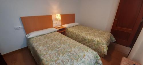 a hotel room with two beds and a night stand at Casablanca 95 in Vigo