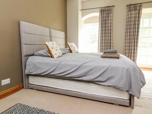 a large bed in a bedroom with a window at 9 Riverside Walk in Skipton