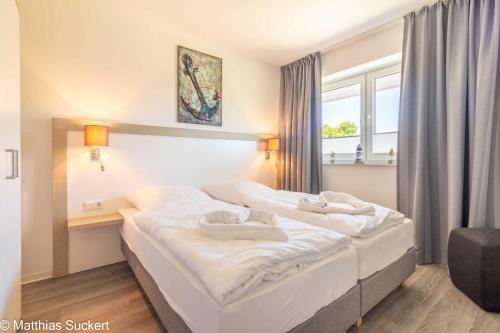 a hotel room with two beds and a window at Fewo Lachmööv Haus Norderney in Hooksiel