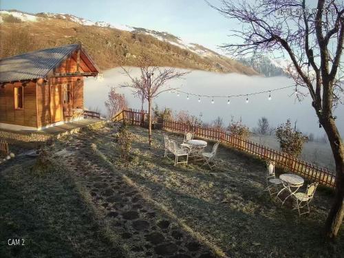 a cabin with a table and chairs in front of a lake at Chestnut Hill in Kolgecaj