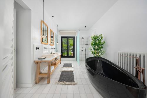 a bathroom with a black tub and a sink at Yacht La Maison in Fethiye