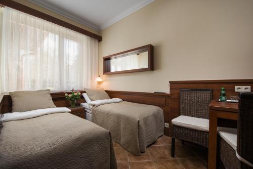 Habitación hospitalaria con 2 camas y espejo en Willa Korona, en Hel