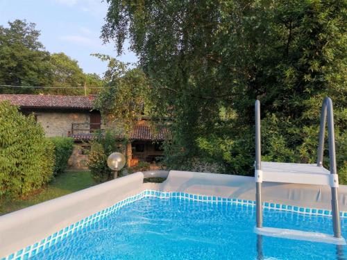 a swimming pool with a chair in a yard at IseoLakeRental - Chalet di Elena in Solto Collina