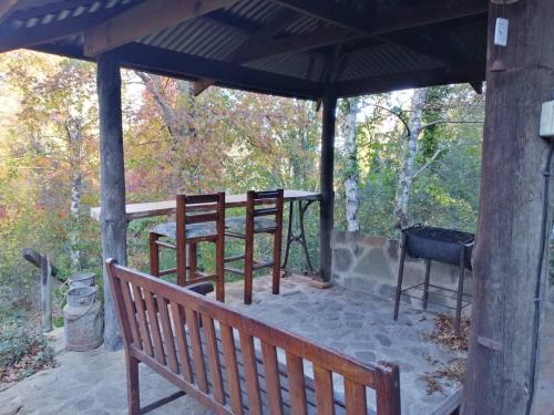 a covered porch with a bench and a grill at Maple Grove in Hogsback