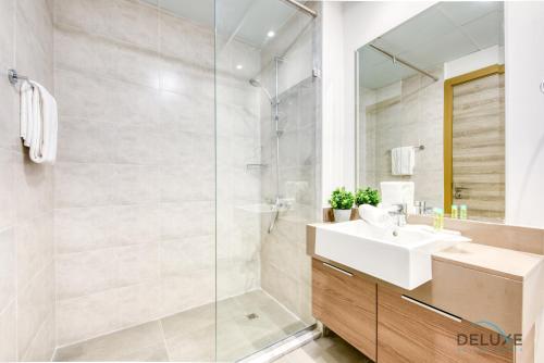 a bathroom with a sink and a shower at Precious Studio at Bloom Towers JVC by Deluxe Holiday Homes in Dubai