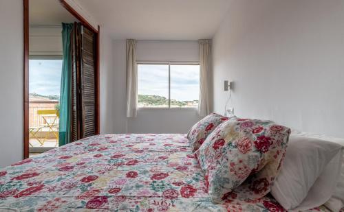 sypialnia z łóżkiem z poduszkami i oknem w obiekcie Casa Creu Mar w Sant Feliu de Guixols
