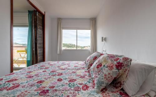 ein Schlafzimmer mit einem Bett mit Kissen und einem Fenster in der Unterkunft Casa Creu Mar in Sant Feliu de Guixols